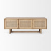 Front view of the Grier media unit in natural light mango wood featuring three doors with woven rattan cane inserts and a minimalist T-base frame