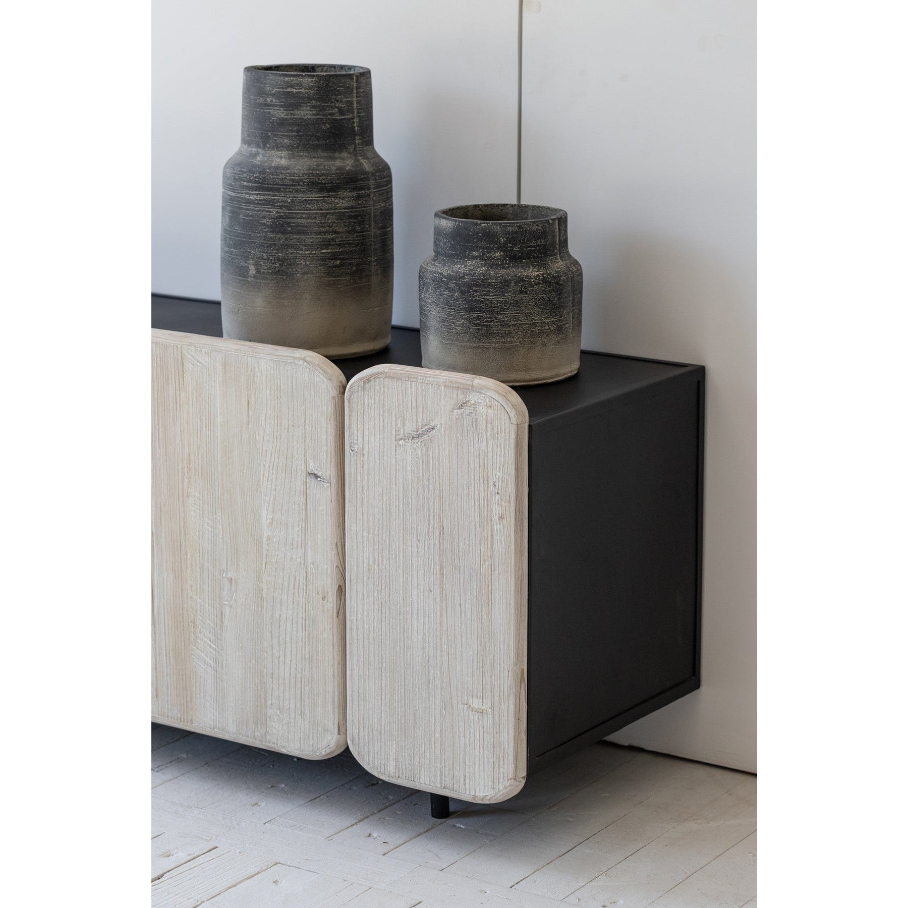 Three-quarter perspective view of the Renaissance sideboard featuring a deep charcoal mango wood finish and hand-carved textured relief panels across four doors