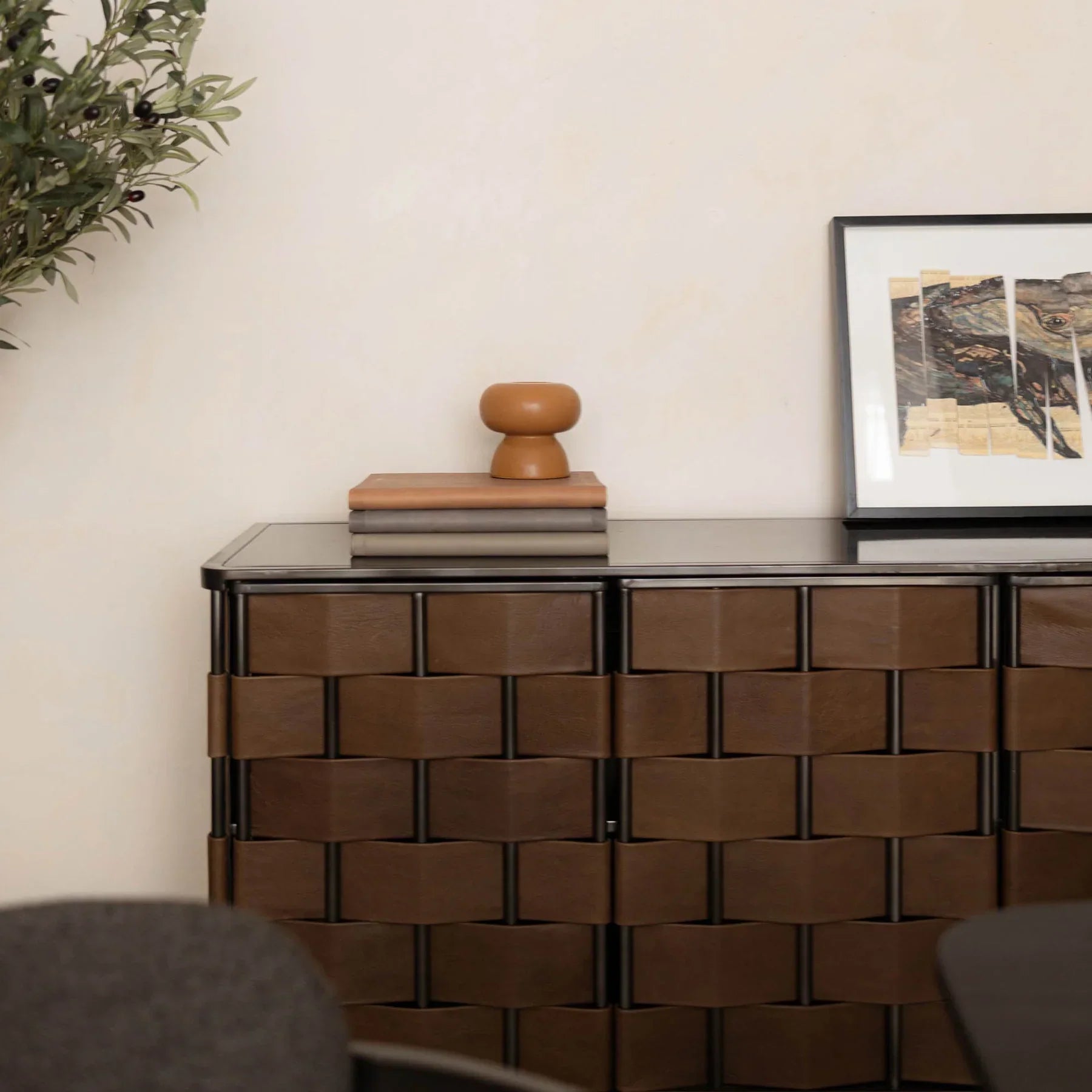 Front view of the Bishop sideboard featuring a hand-woven cognac brown leather panel design set within a slim dark metal frame