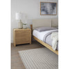 Close-up lifestyle shot featuring the Havn nightstand styled with a modern lamp next to a coordinating upholstered bed frame