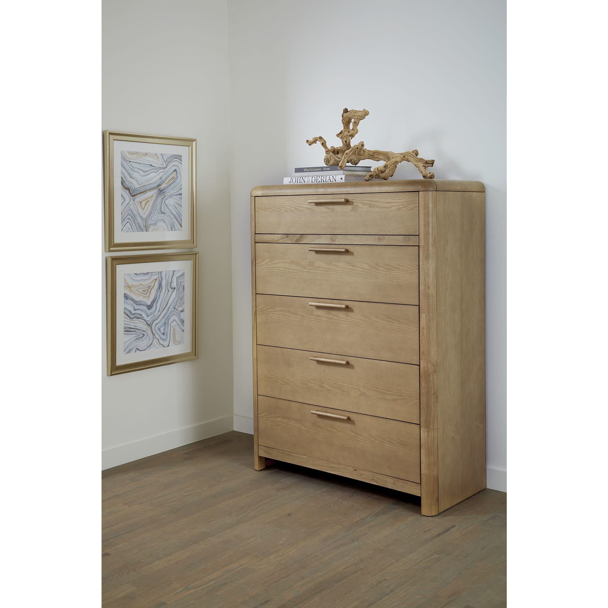 Studio lifestyle shot featuring the Havn 5-drawer chest styled with a decorative sculpture in a bright, modern master suite