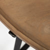 Detailed view showcasing the organic wood grain patterns and warm brown finish of the circular Helios tabletop