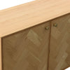 High-angle close-up highlighting the tactile herringbone wood inlay and the small round brass door knobs