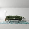 Lifestyle shot featuring the Himalaya nesting tables styled as a central coffee table in a bright living room with a green sectional sofa and teal rug