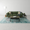 Perspective lifestyle view showing the nesting tables paired with a modern green sofa and a tall wood pedestal floor lamp