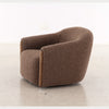 Side profile demonstrating the organic curved backrest and the substantial thickness of the upholstered frame