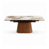 Front view of the Hyld extendable dining table featuring a white patterned ceramic top and a substantial walnut-finished wood pedestal base