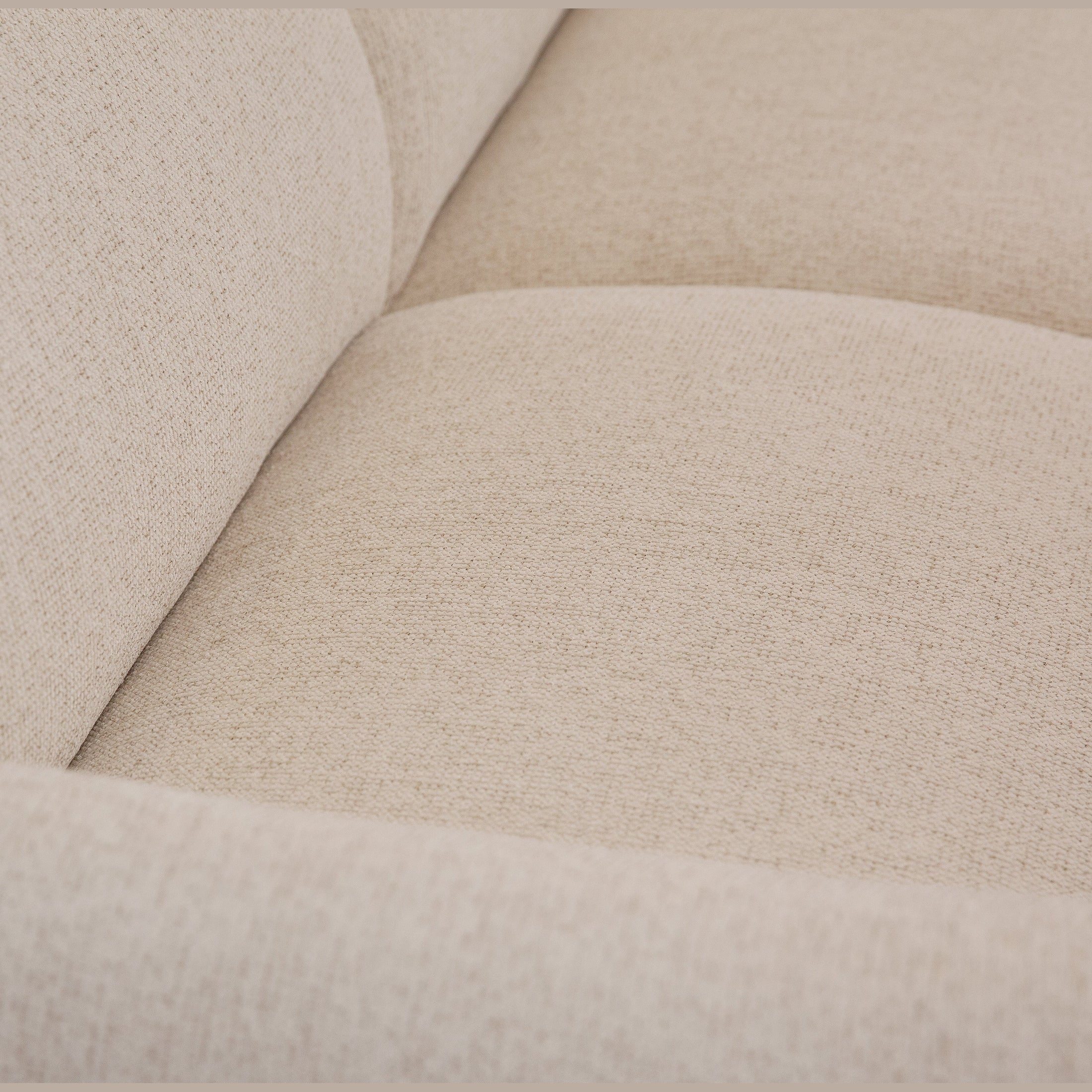 Close-up detail of Idony sofa seat cushion in beige textured fabric upholstery