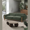The Idun green velvet sofa styled with a unique organic-shaped coffee table