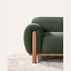Close-up of the rounded armrest and integrated wooden leg on the Idun sofa