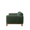 Side profile view of the Idun green velvet sofa highlighting the wooden base