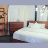 Lifestyle shot featuring the wall rack in a bedroom setting next to a wooden dresser and modern lighting