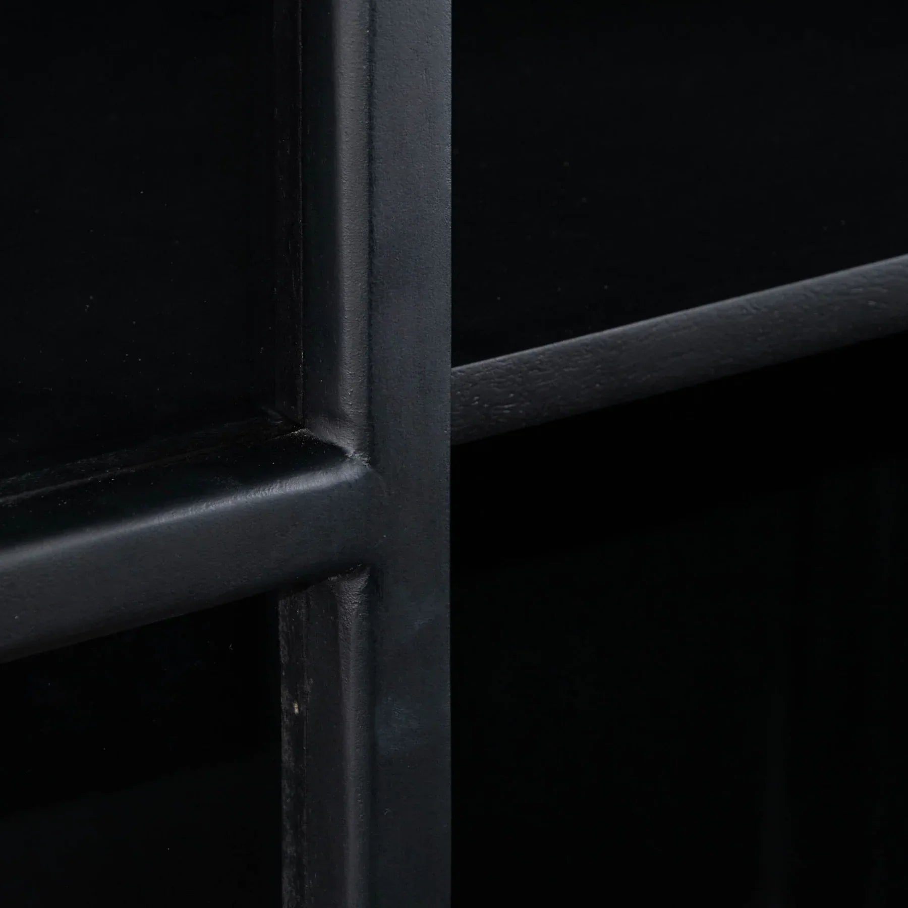 Three-quarter perspective view of the Caged tall cabinet featuring a sleek white exterior black metal-framed glass doors and a minimalist black metal base