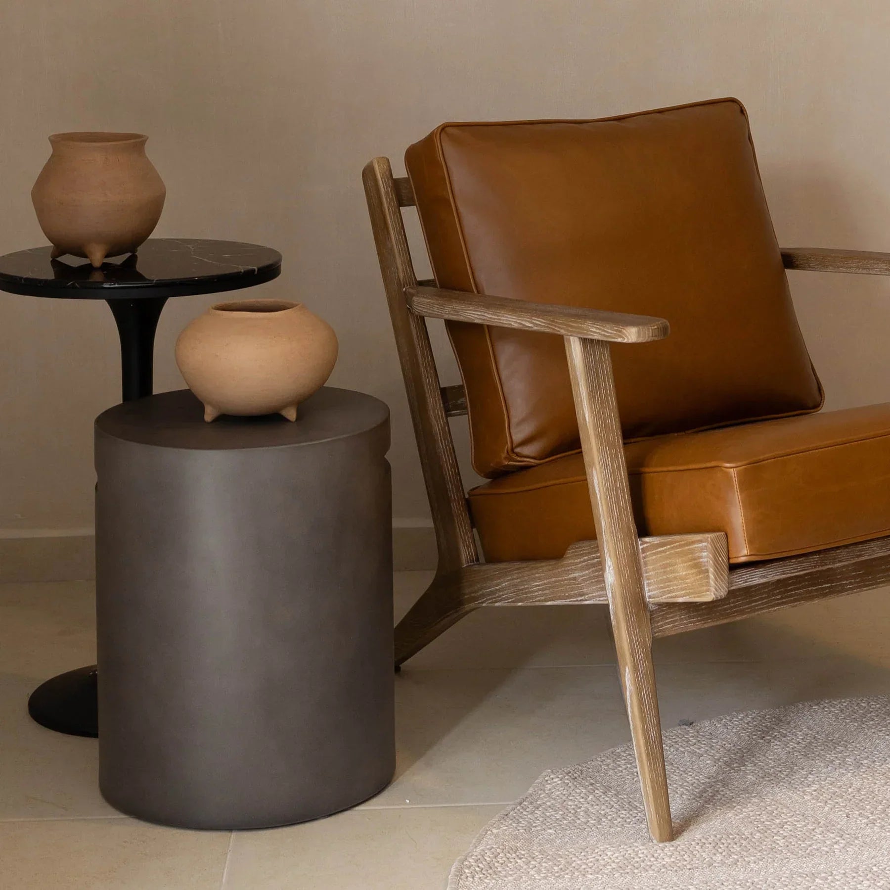 Front view of a cylindrical dark grey concrete side table featuring a minimalist drum silhouette and subtle integrated handle notches near the top rim