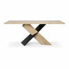 Front view of the Instinct dining table featuring a natural wood top and a sculptural black and oak interlocking X-style base