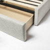 Side perspective view of the bed with a spacious integrated storage drawer extended to show internal wooden construction