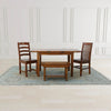 Lifestyle perspective showing the extension table paired with a matching wooden bench and two ladder-back chairs on a light blue rug