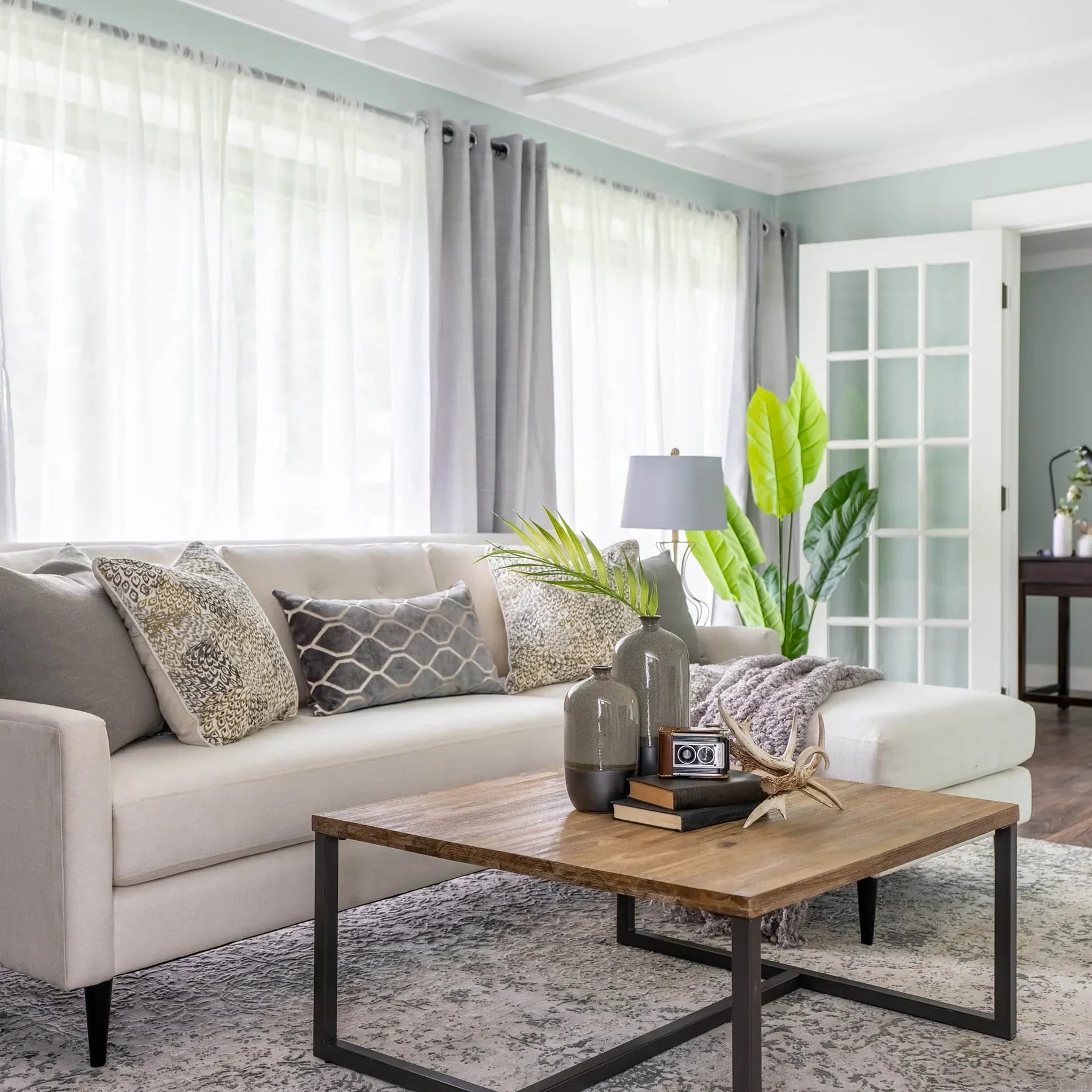 High-angle lifestyle shot of the Irondale table styled with a white sectional sofa and indoor greenery