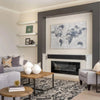 Lifestyle view showcasing the wood and metal table paired with grey upholstered armchairs and a decorative fireplace
