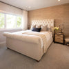 Lifestyle shot featuring the Irondale nightstand styled in a warm bedroom setting next to a cream button-tufted headboard
