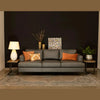 Wide lifestyle view showing two Irondale side tables flanking a dark grey leather sofa in a modern interior setting