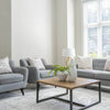 Zoomed-out lifestyle perspective of the Irondale table in a minimalist apartment setting with a grey sofa and floor-to-ceiling windows