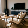 Lifestyle shot featuring the square coffee table styled in a cozy living room with mid-century accent chairs
