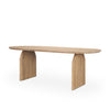 Three-quarter perspective view of the Isla oval dining table featuring a light brown wood finish and modern arched pedestal legs