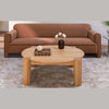 Lifestyle shot featuring the Jack round coffee table styled with a tray and vase in front of a contemporary brown sofa