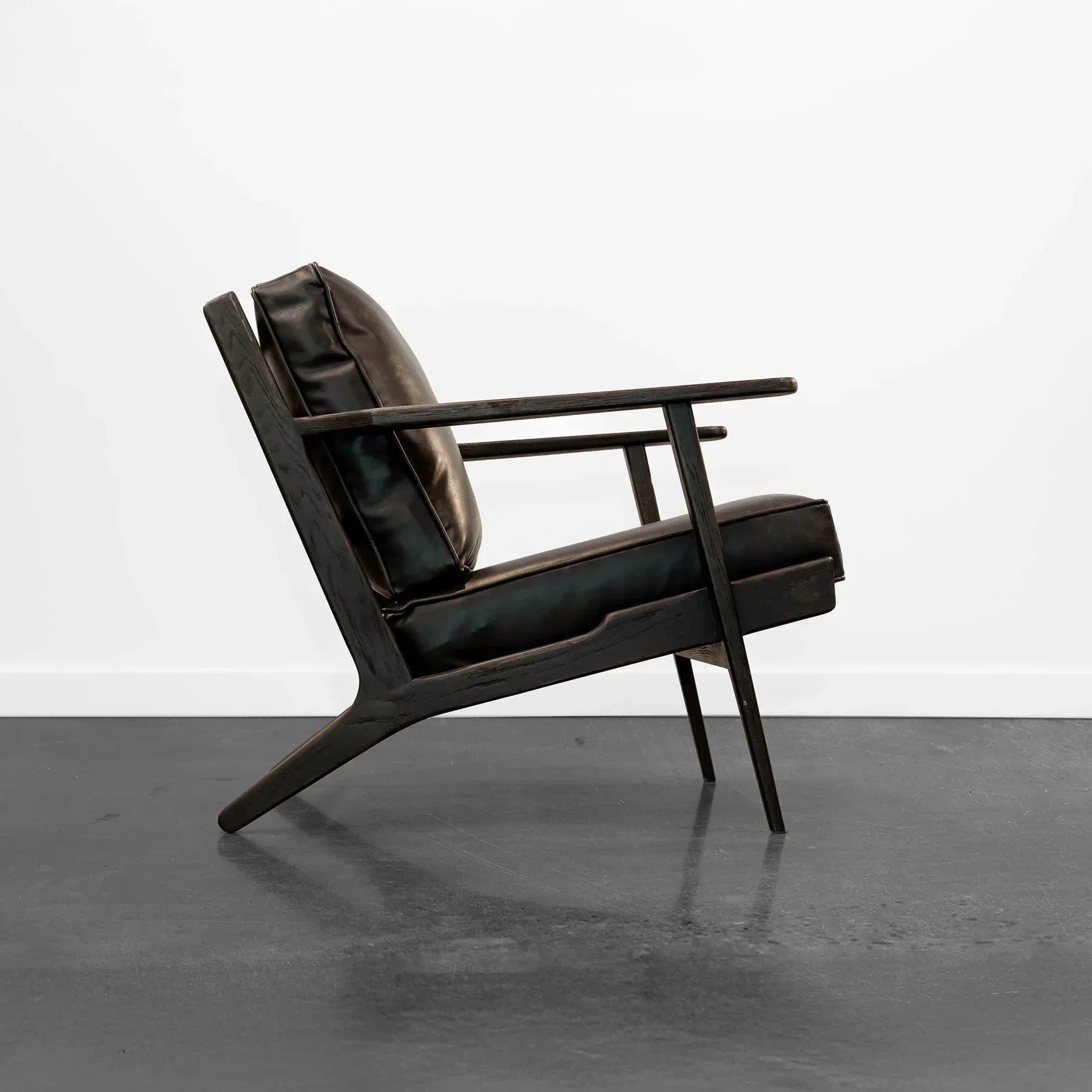 Junior arm chair in black leather in contemporary living room