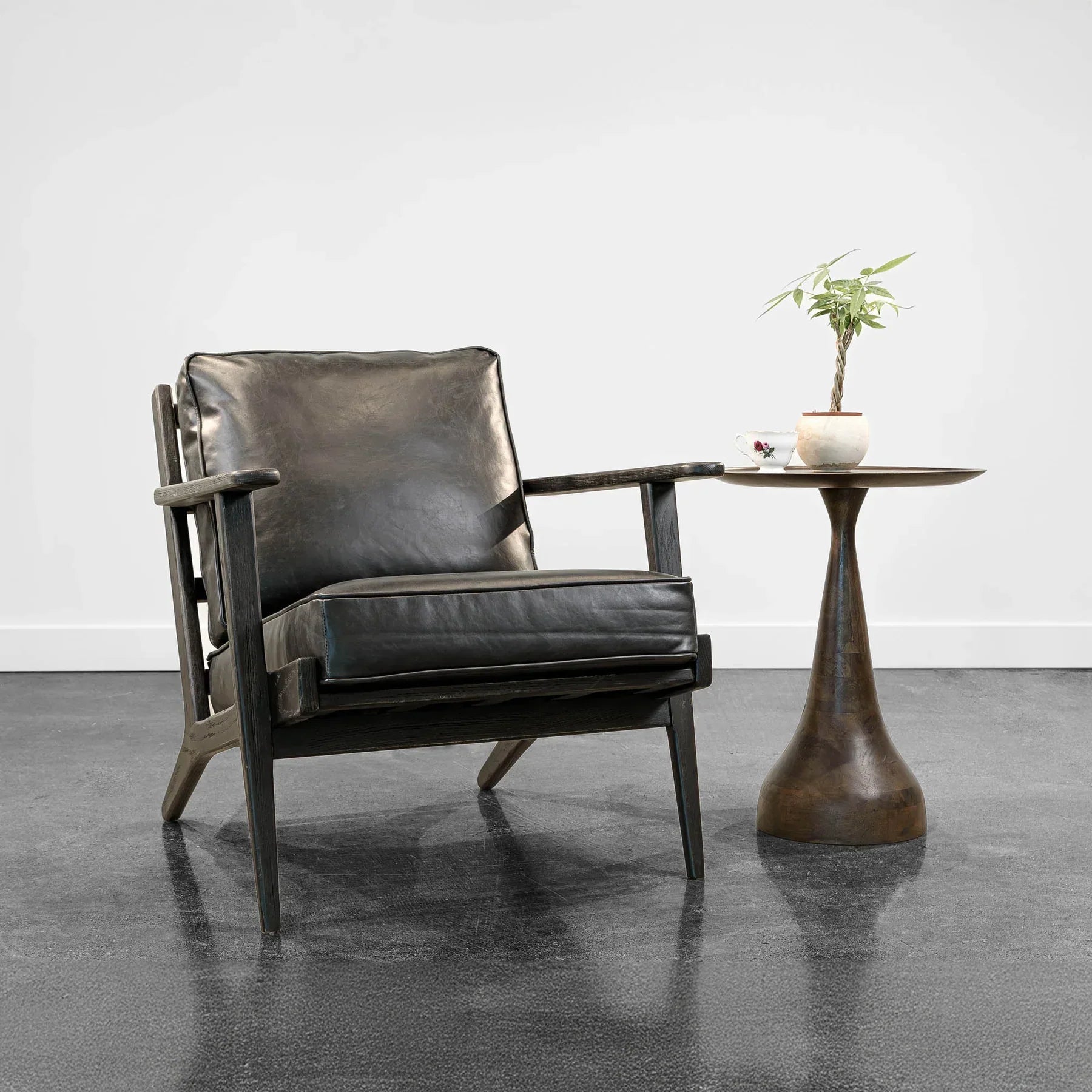 Junior arm chair in black leather in modern interior setting