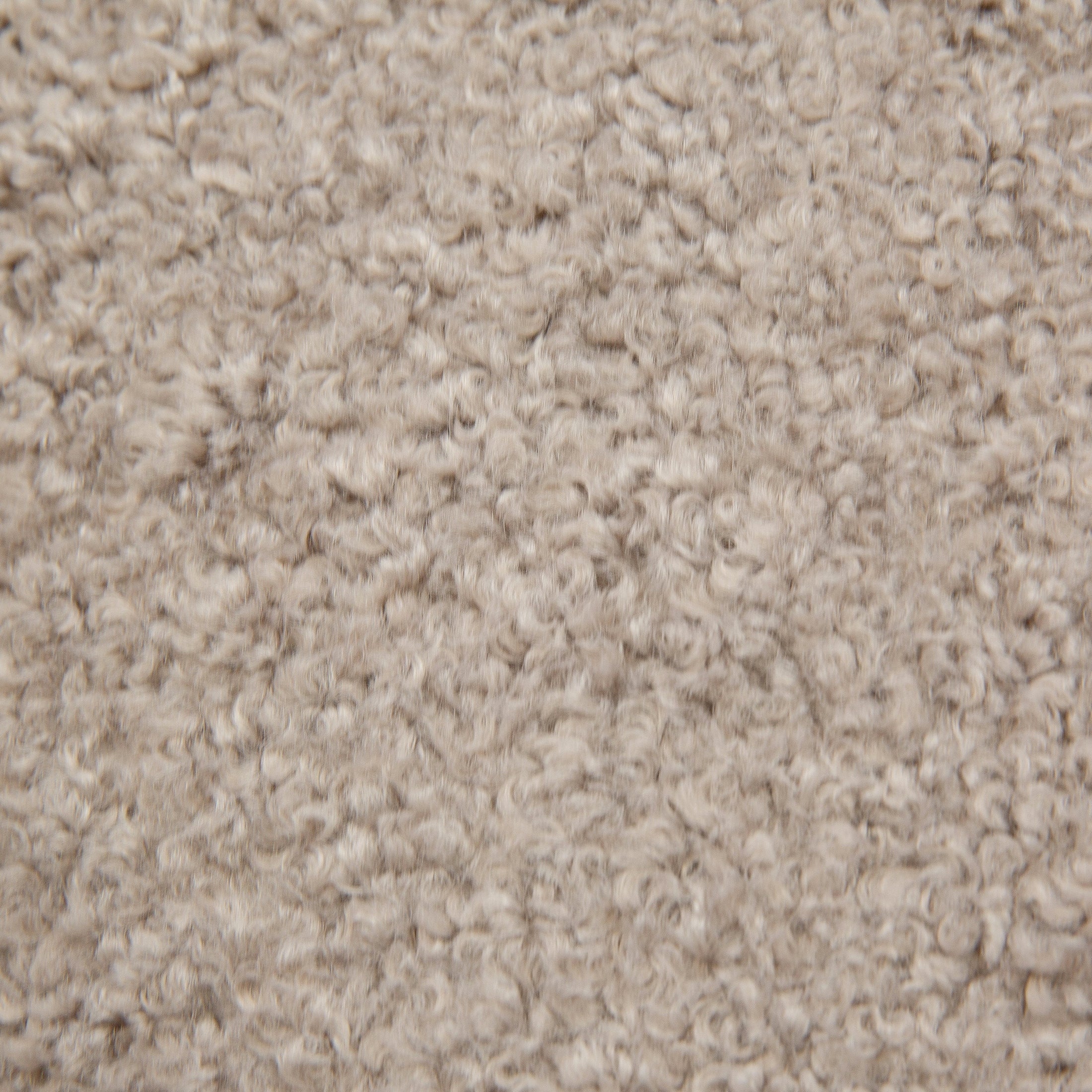 Front view of the Keji Armchair in pebble grey bouclé featuring a rounded silhouette and integrated natural wood frame