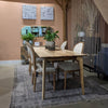 Front view of the Kenzo table variant in a rich dark walnut wood finish with matching tapered legs