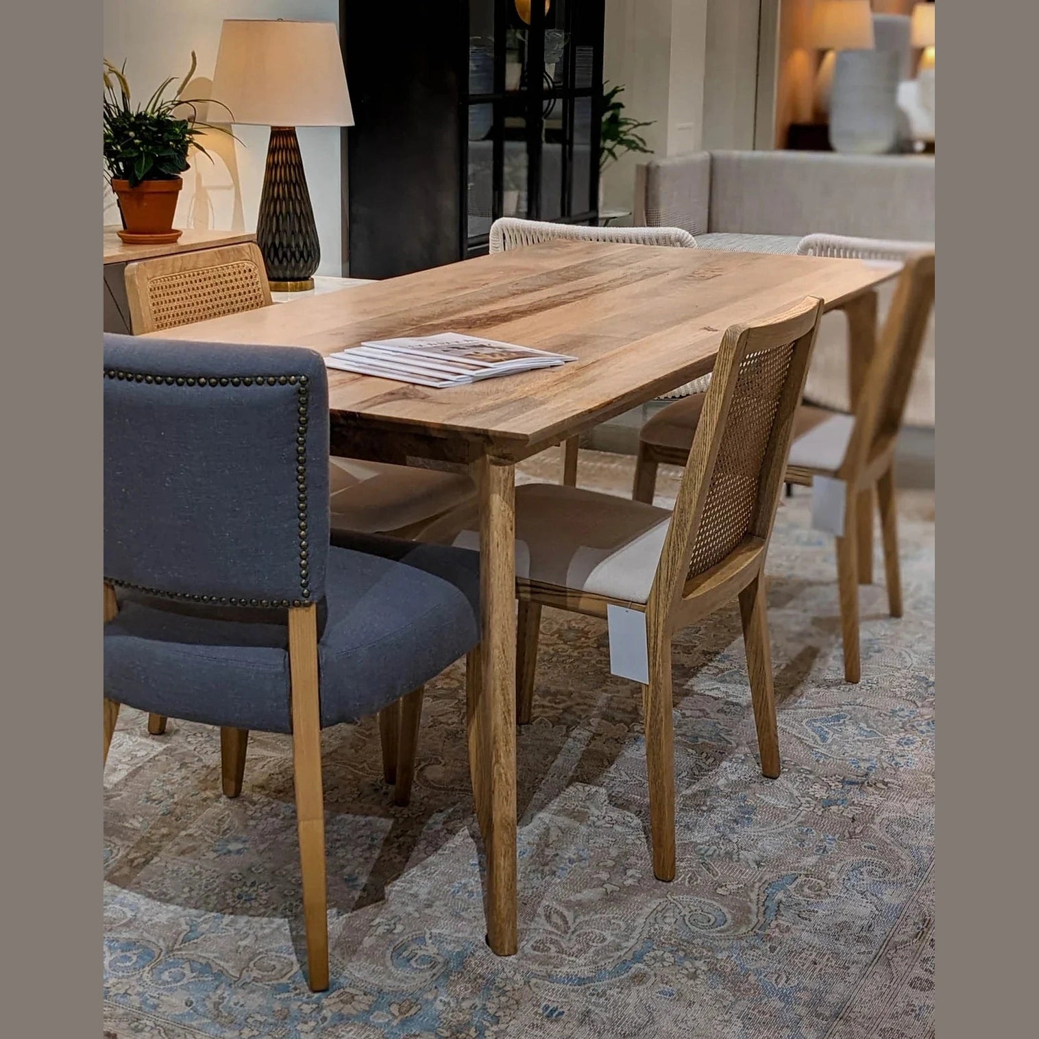 Front view of the Kenzo dining table in a light natural mango wood finish featuring a minimalist rectangular top and rounded tapered legs