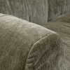 Close-up detail of the rounded armrest on the green Larvik sofa