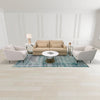 Wide lifestyle view of the Libra nesting tables paired with neutral armchairs and a blue patterned rug in a bright living room