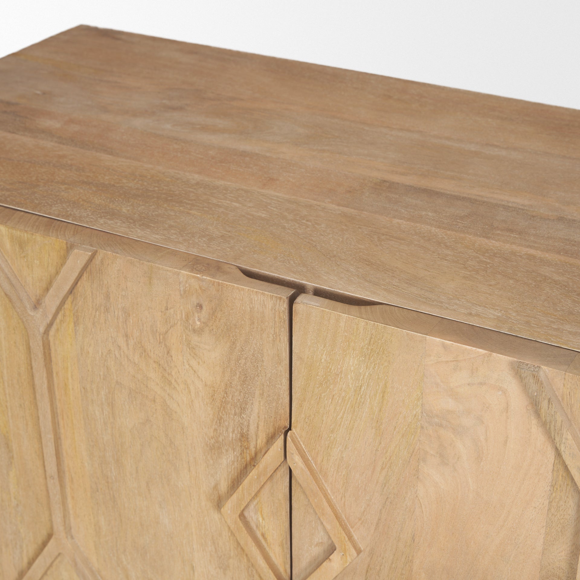 Front view of the Heera accent cabinet featuring a light brown wood finish and a decorative carved diamond motif on the double doors