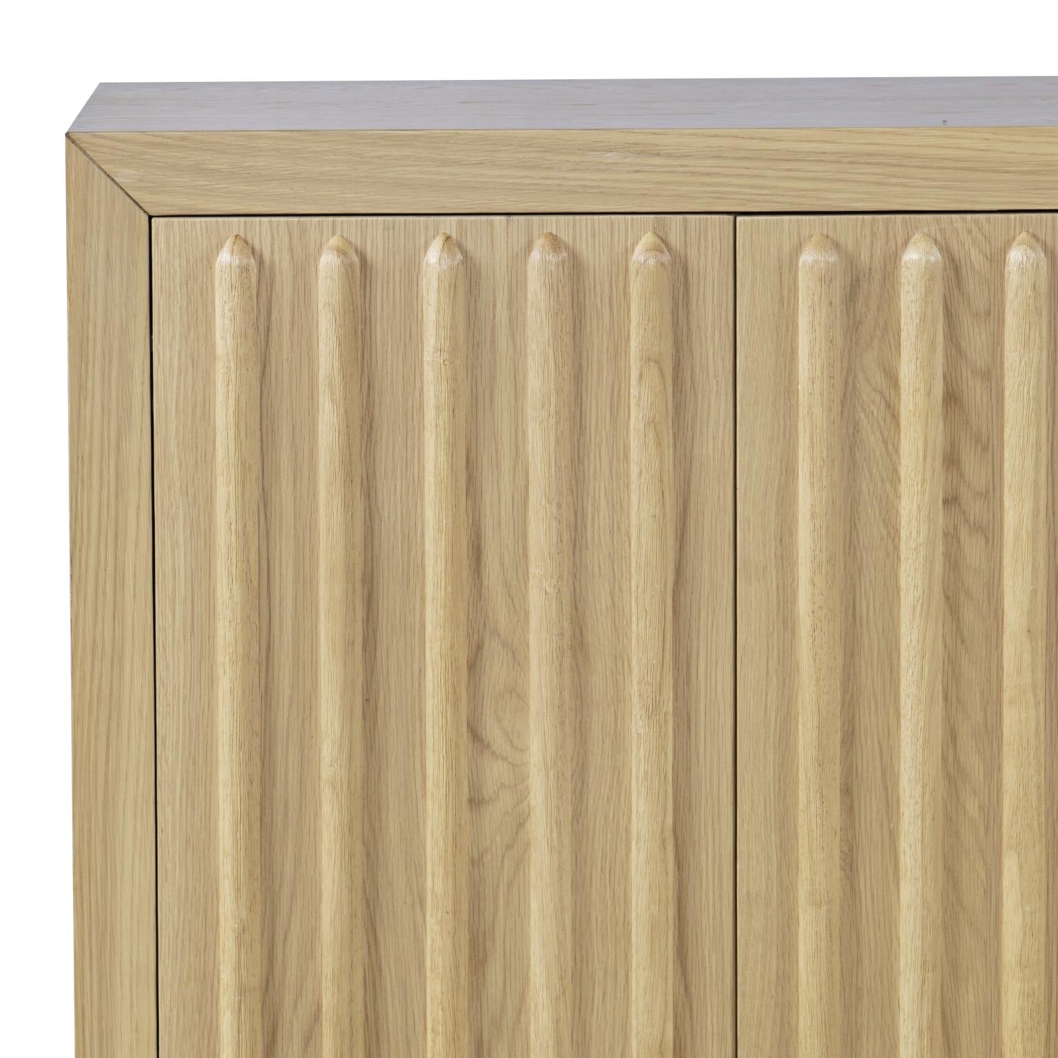 Front perspective view of the Skap 4-door sideboard in a dark oak finish featuring vertical fluted door panels and a matching plinth base