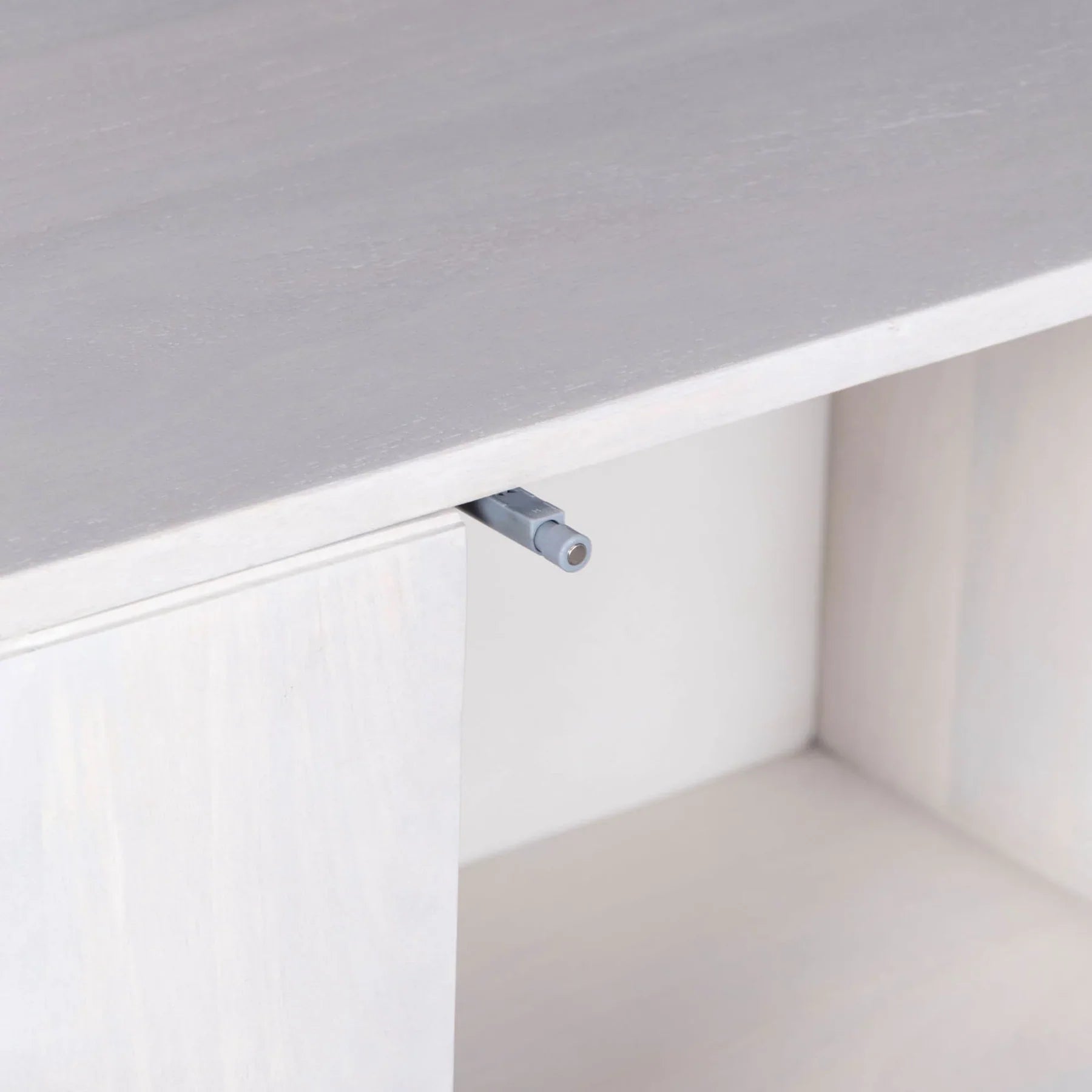Three-quarter perspective view of the Tempo sideboard featuring a light white wash finish and architectural arched carved door panels