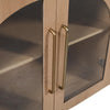 Macro shot focusing on the contemporary long gold handles integrated into the arched glass cabinet doors