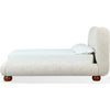 Side profile view highlighting the low-slung upholstered base and the decorative dark walnut finish bun feet