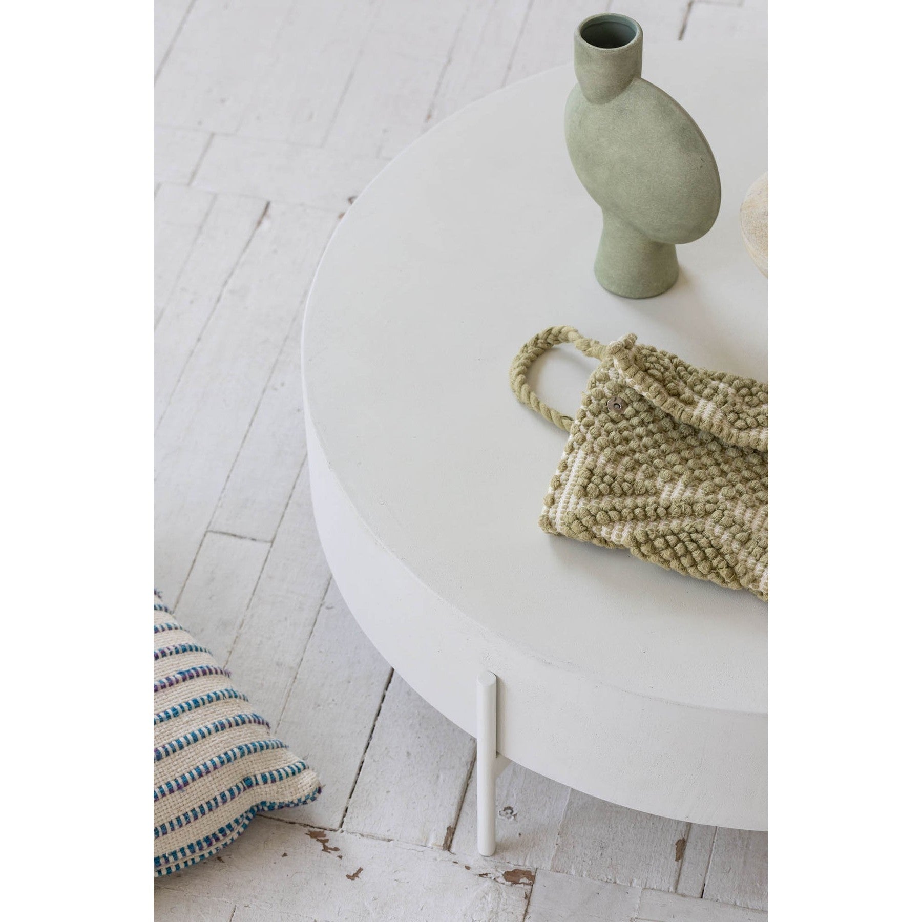 Front view of the Luna coffee table featuring a thick circular drum-style top in white concrete supported by a minimalist four-leg metal base