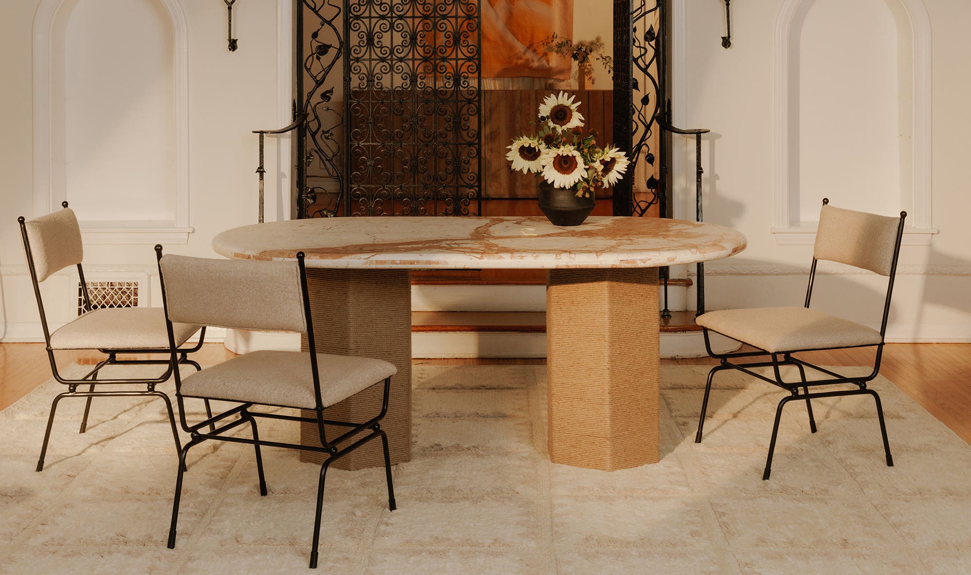 Lifestyle shot featuring the Sartoria marble table in an upscale interior styled with contemporary metal-frame dining chairs