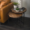 Lifestyle view of the nesting tables styled next to a cognac leather sofa with small potted plants