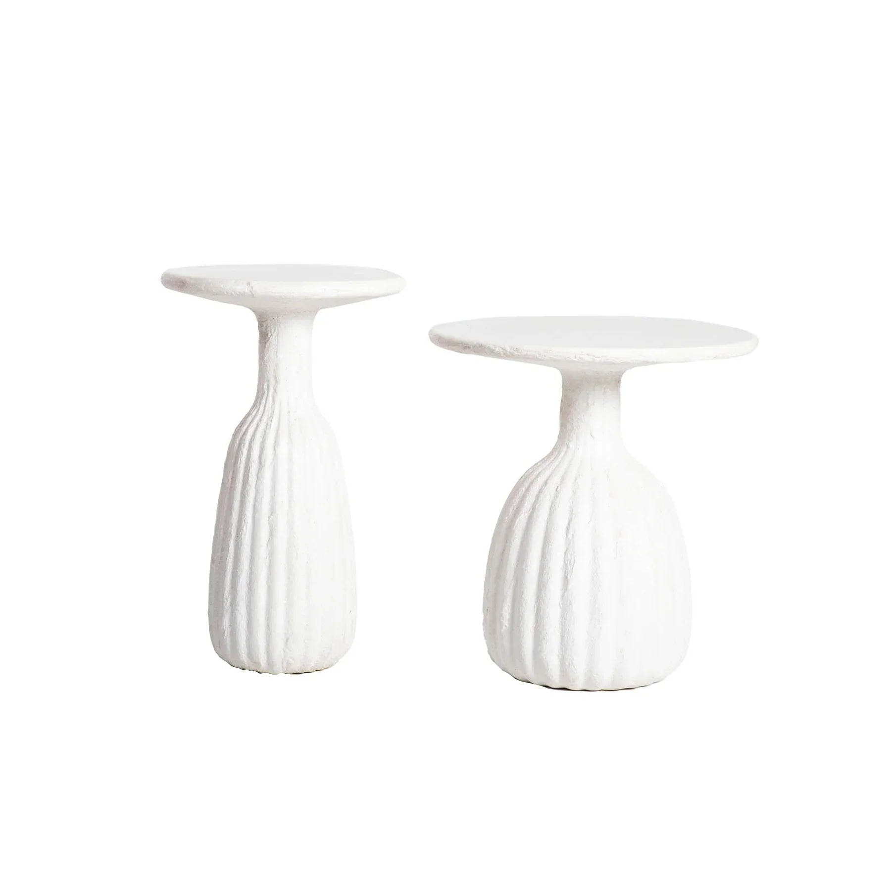 Front view of a white minimalist side table featuring a circular top and a unique fluted hourglass pedestal base with a textured plaster-like finish