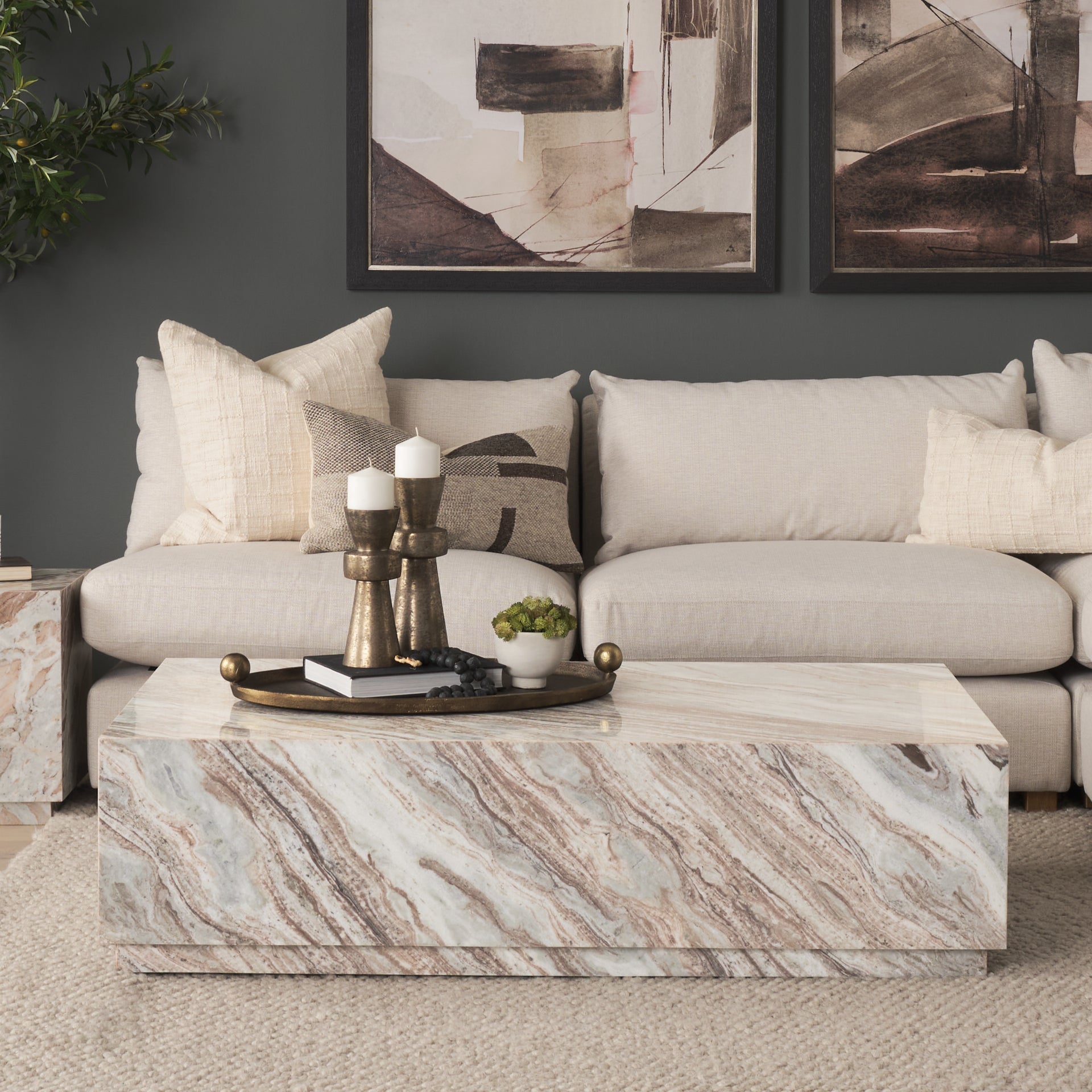 Lifestyle shot featuring the Matteo marble coffee table styled in a modern living room with a neutral sectional sofa