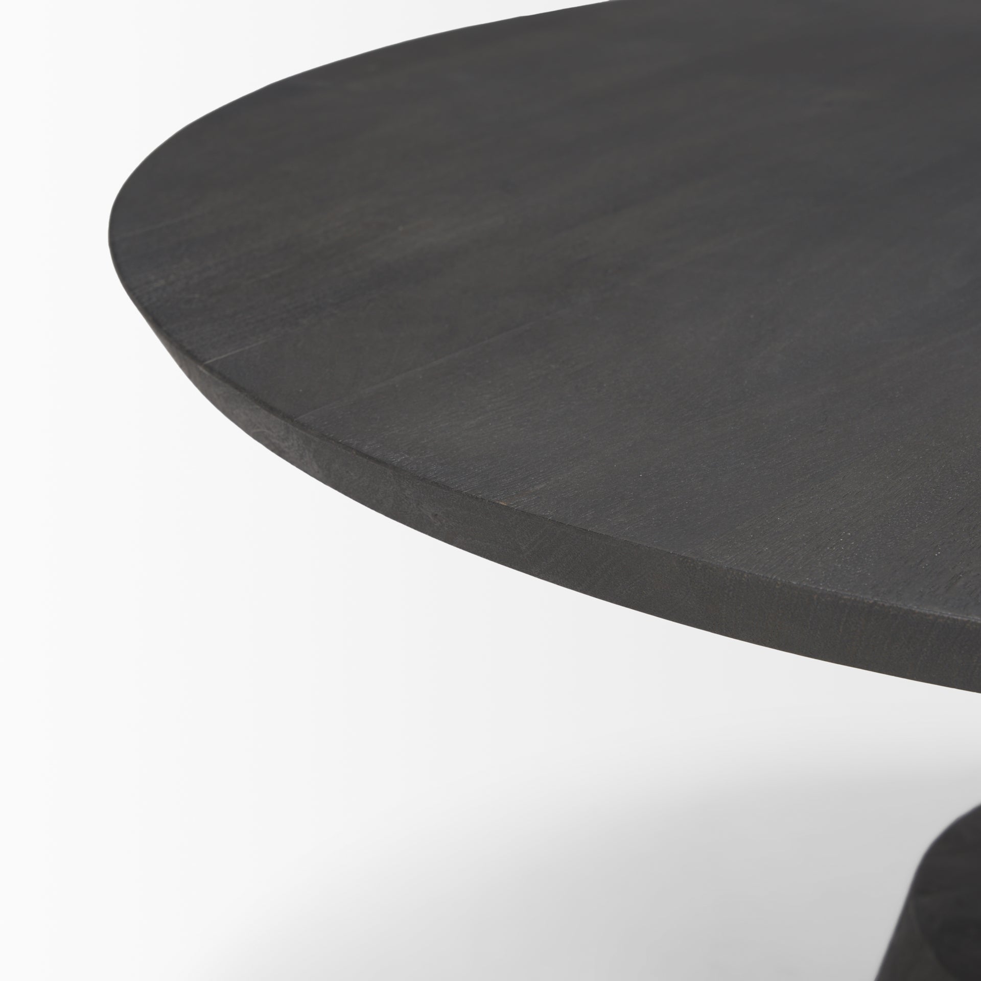 Close-up shot focusing on the smooth tapered edge of the round wood tabletop and charcoal finish