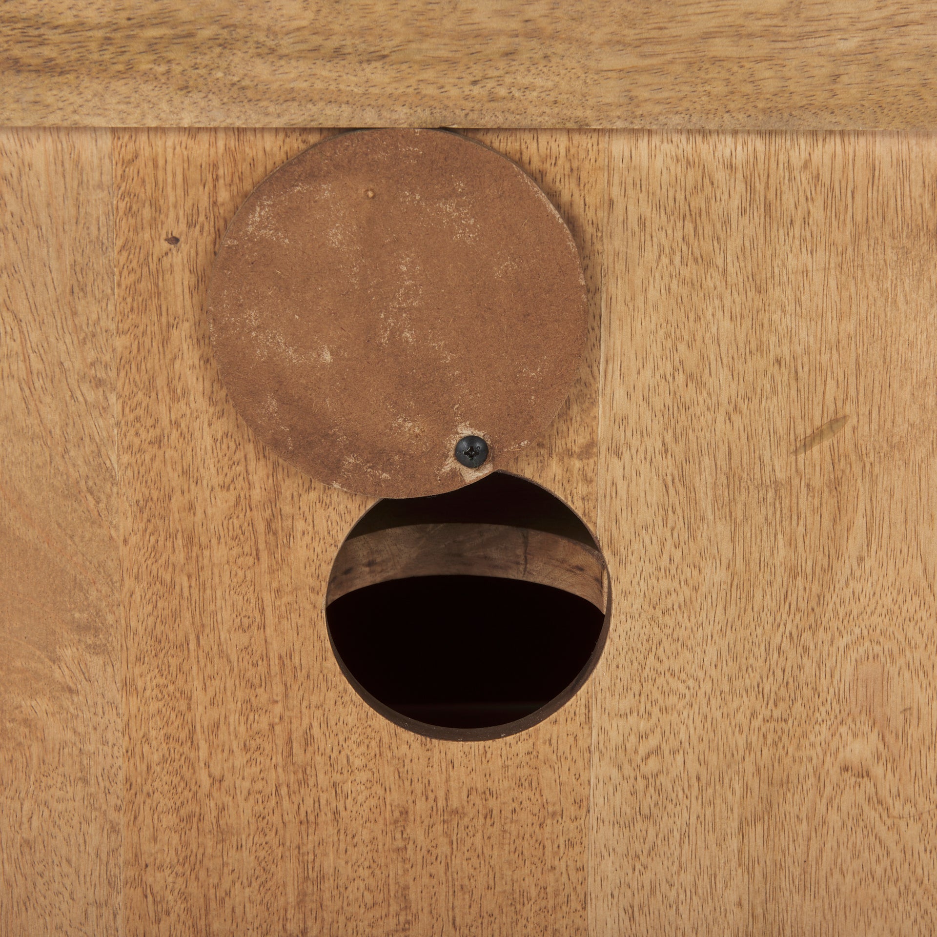 Close-up shot of the functional wood cover for the circular cable management port on the back panel