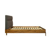 Side profile view showcasing the slim tapered wood legs and the secure attachment of the cushioned grey headboard
