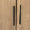Macro shot focusing on the slim matte black vertical handles against the textured lioness wood finish